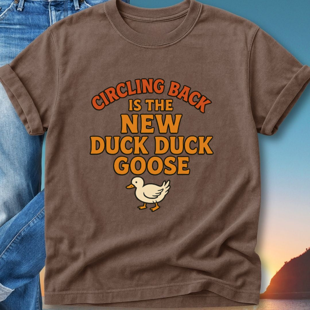 Brown t-shirt with text "Circling back is the new duck duck goose" and a duck graphic.