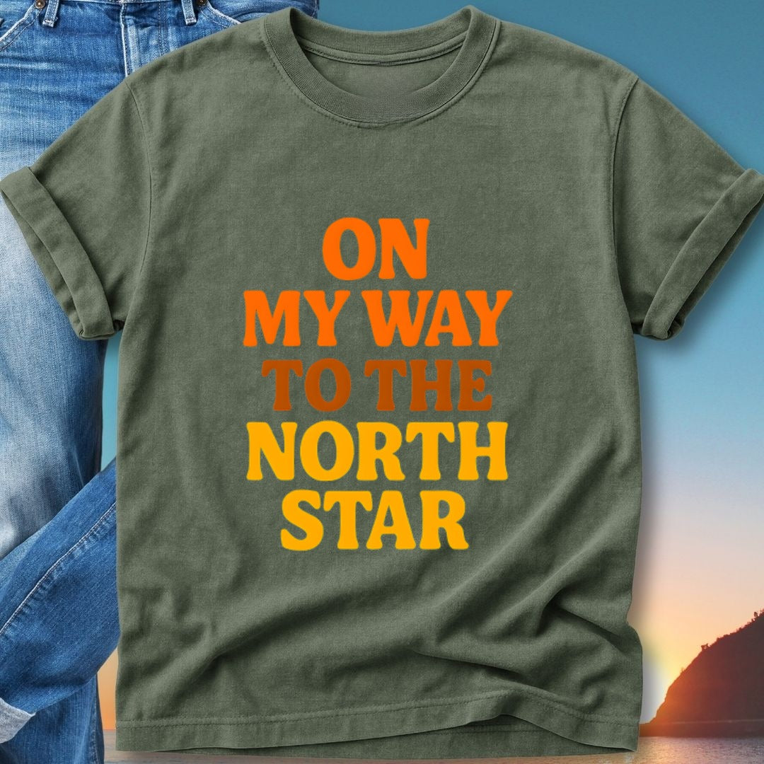 Green t-shirt with "On My Way To The North Star" text in orange and yellow.