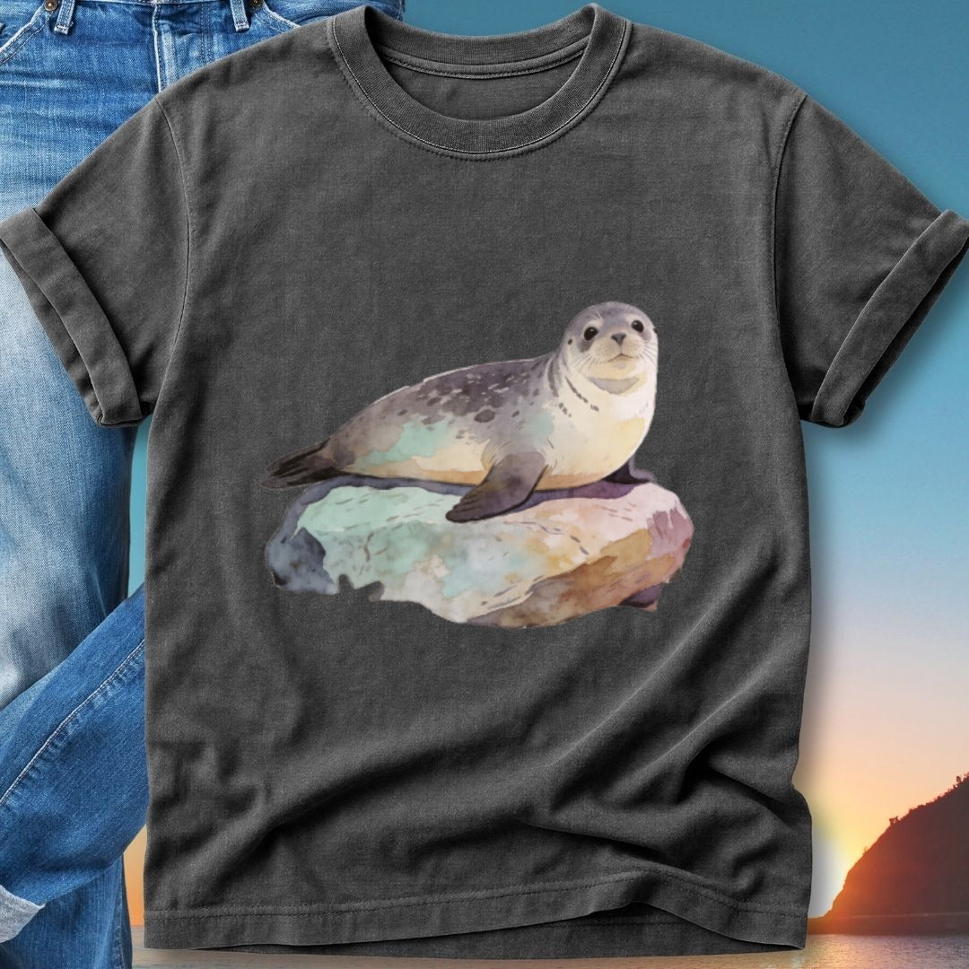 Seal resting on a rock with a sunset background, printed on a dark t-shirt.