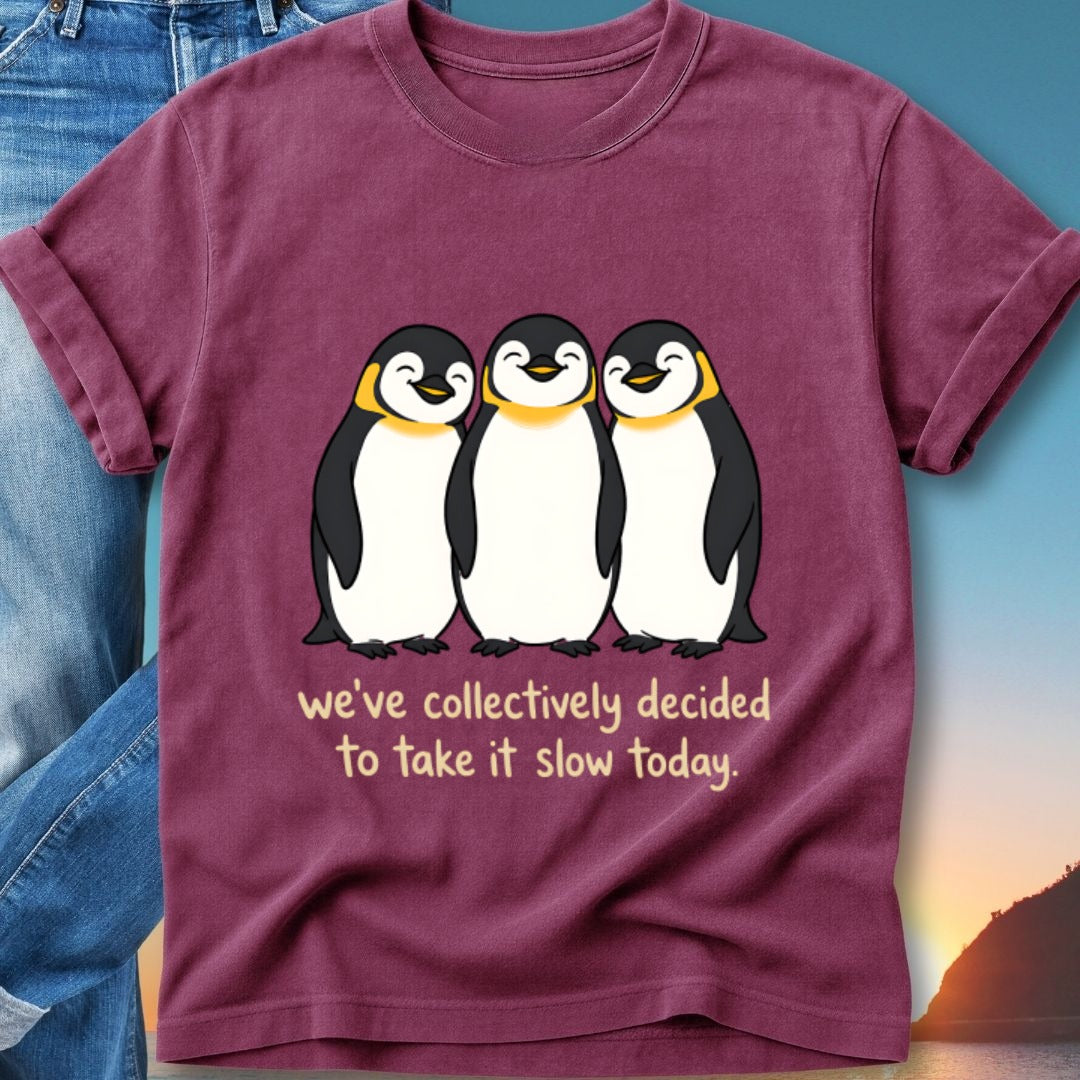 Three smiling penguins on a t-shirt with text "we've collectively decided to take it slow today."