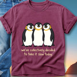 Three smiling penguins on a t-shirt with text "we've collectively decided to take it slow today."