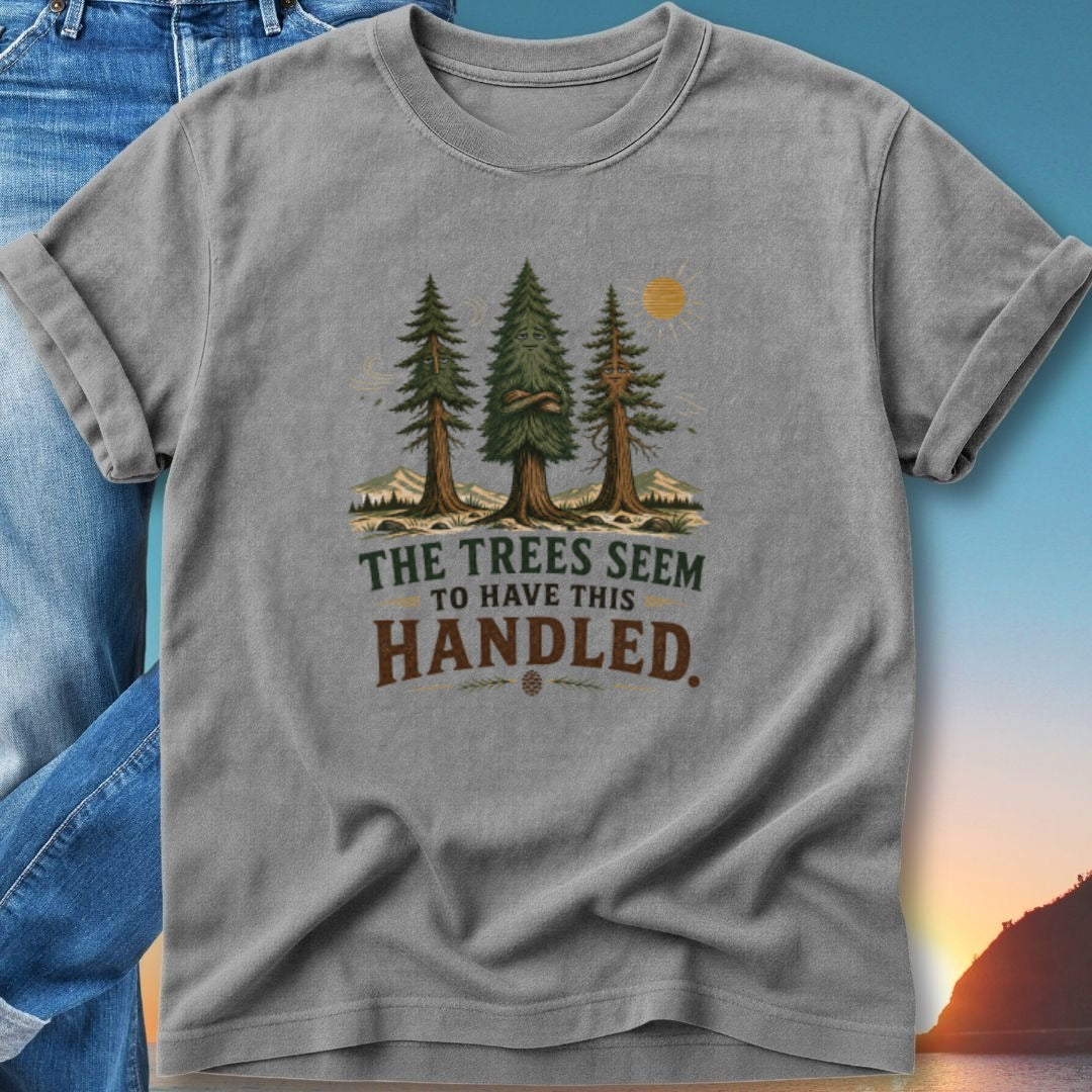 Gray t-shirt with trees and mountains graphic, "The Trees Seem To Have This Handled" text.