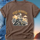 Brown t-shirt with "Peak Behavior" text above a seated goat on a mountain.
