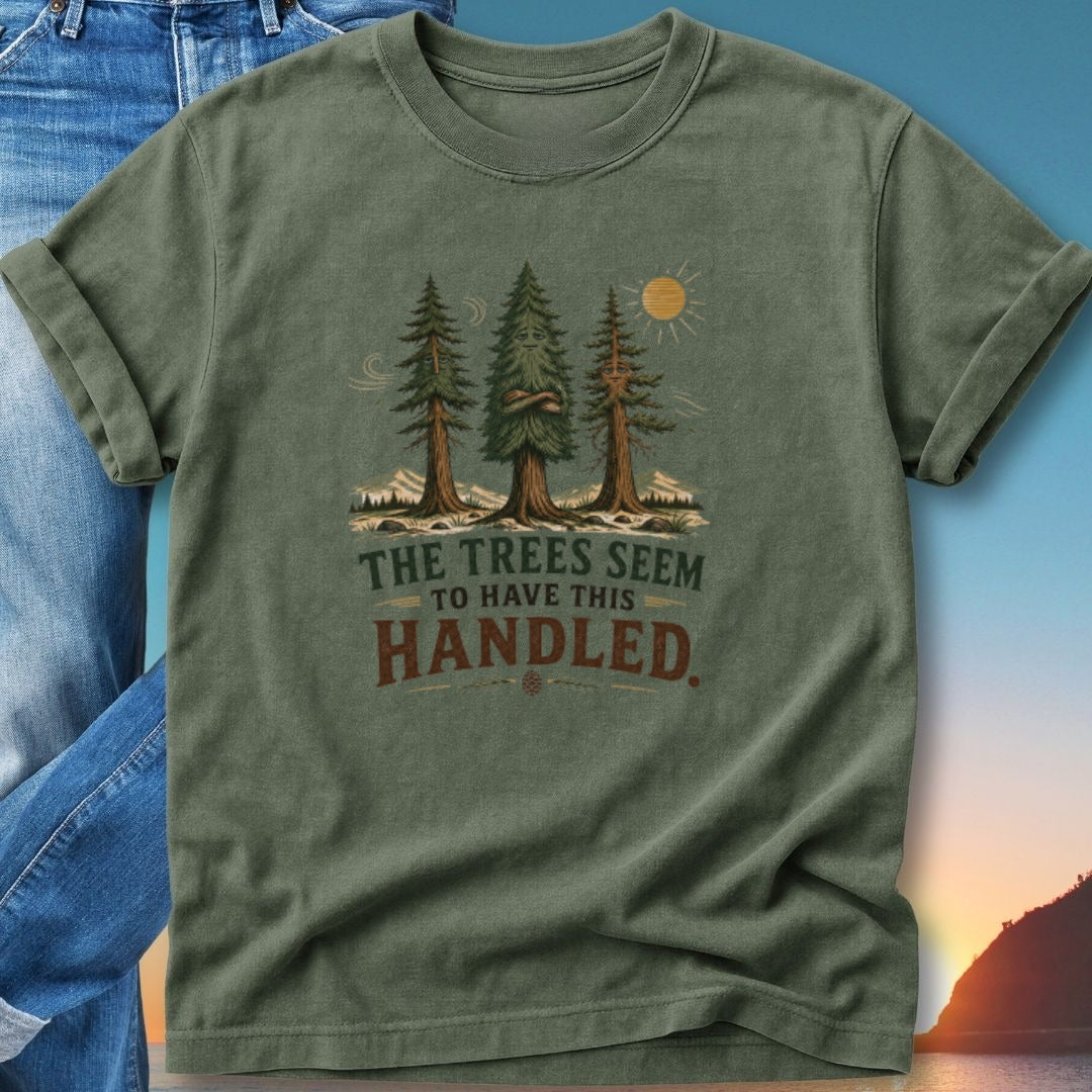 Green t-shirt with trees and mountains graphic, text reads "The trees seem to have this handled."