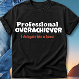 Black t-shirt with white text "Professional Overachiever" and red text "I delegate like a boss!".