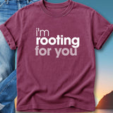 Maroon t-shirt with white text "I'm rooting for you" against a sunset backdrop.