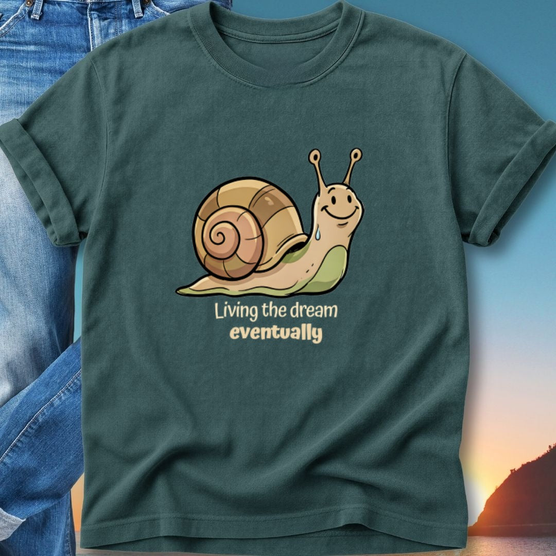 Snail with text "Living the dream eventually" on a dark teal t-shirt.