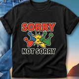 Black t-shirt with "SORRY NOT SORRY" text and colorful pins.
