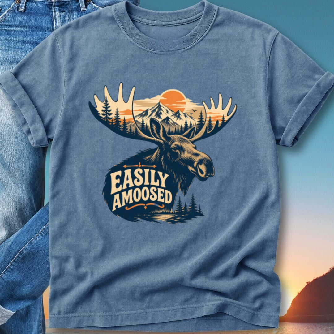 T-shirt graphic of a moose head with mountains, trees, and a sunset behind it.