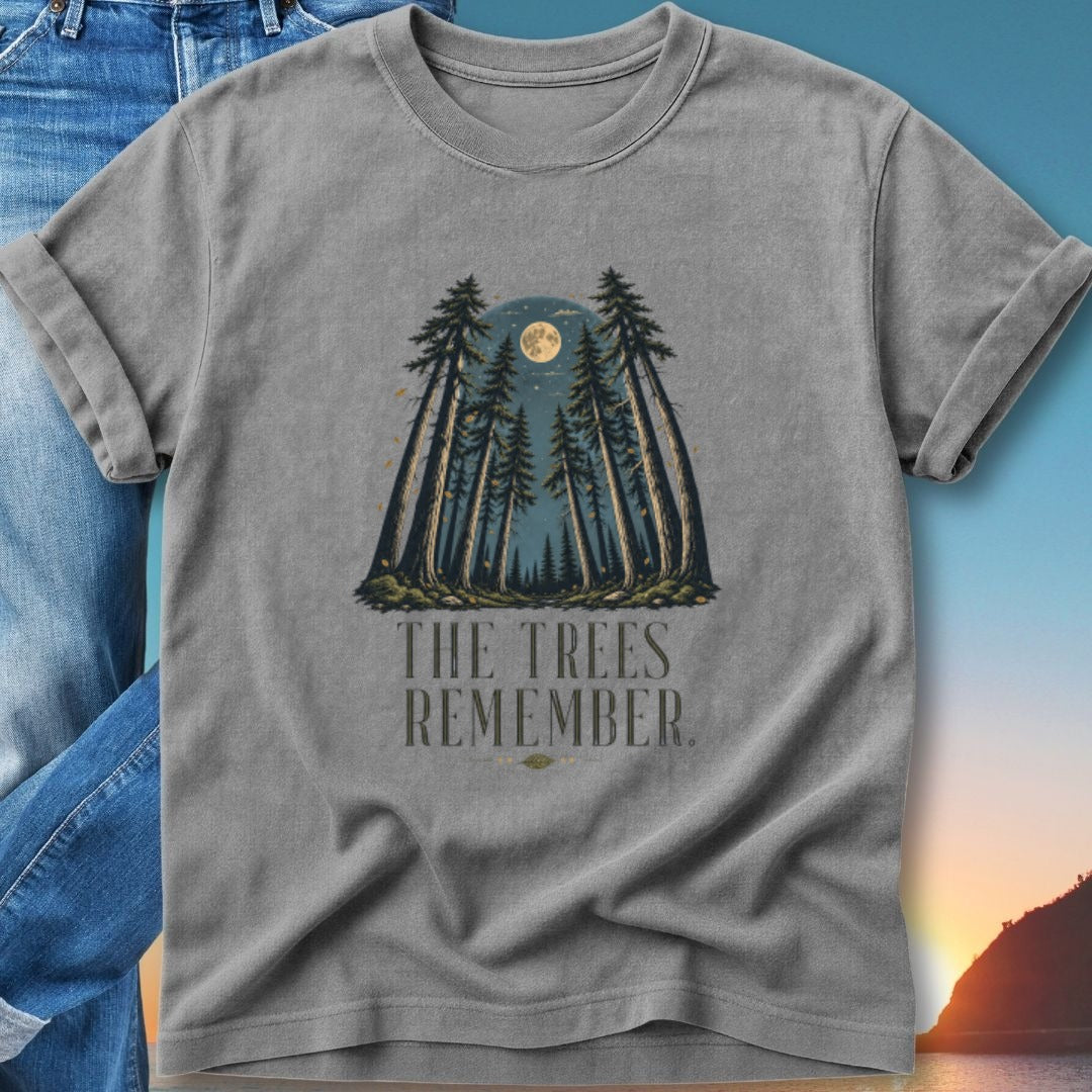T-shirt featuring tall pine trees under a full moon with text "The Trees Remember."