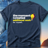 Navy t-shirt with text "the moment I created additional work for myself..." and a lightbulb graphic.