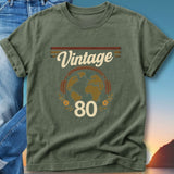 Green t-shirt with "Vintage 80" text, headphones and globe graphic.