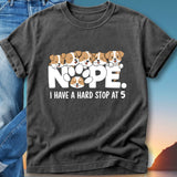 Dark t-shirt with five puppies forming the word "NOPE".