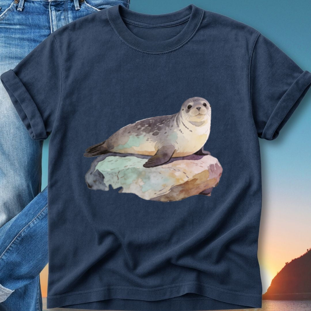 Seal resting on a rock with a sunset background, on a navy t-shirt.