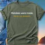 Green t-shirt with "Mistakes were made. Not by me, obviously." text.