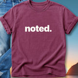 Maroon t-shirt with "noted." printed in white text.