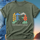 Olive green t-shirt with a winding path and colorful foliage, reading "I trust this path to sunlight."