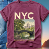 Maroon t-shirt with NYC graphic of park bridge, skyline, and text.