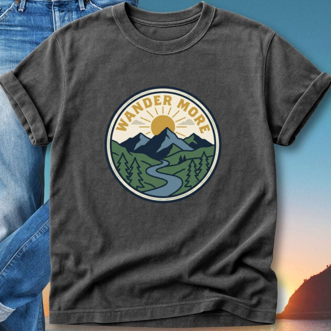 Graphic t-shirt with "Wander More" text in a circular mountain landscape design.