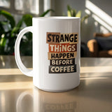 White mug with "STRANGE THINGS HAPPEN BEFORE COFFEE" text.
