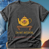 Yellow teapot with floral design on shelf, "I'm not antisocial, I'm just currently on an unannounced sabbatical in the kitchen."