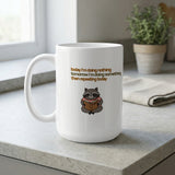 White mug with raccoon reading book and text "today I'm doing nothing then repeating today".