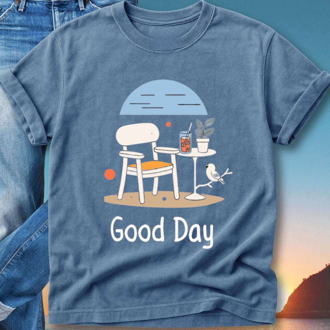 Blue t-shirt with a drawing of a chair, table, drink, and bird.
