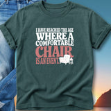 Dark t-shirt with text: "I have reached the age where a comfortable chair is an event."