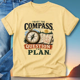 Yellow t-shirt with "Trust the Compass, Question the Plan" and compass graphic.