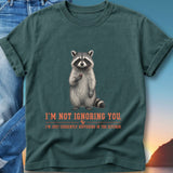 T-shirt with raccoon holding berry and text "I'm not ignoring you, I'm just currently buffering in the kitchen."