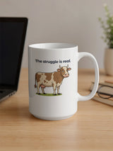 White mug with a cartoon cow and text: "The struggle is real."