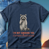 Navy t-shirt with raccoon holding berry and text "I'm not ignoring you, I'm just currently buffering in the kitchen."