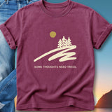 Maroon t-shirt with a minimalist forest and sun design, and text "SOME THOUGHTS NEED TREES."