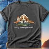 Basset hound tangled in colorful cords with "this got complicated" text.