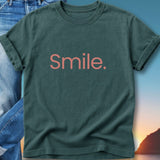 Dark green t-shirt with "Smile." in pink text.