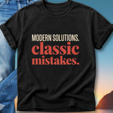 Black t-shirt with "Modern Solutions. Classic Mistakes." text in white and red.