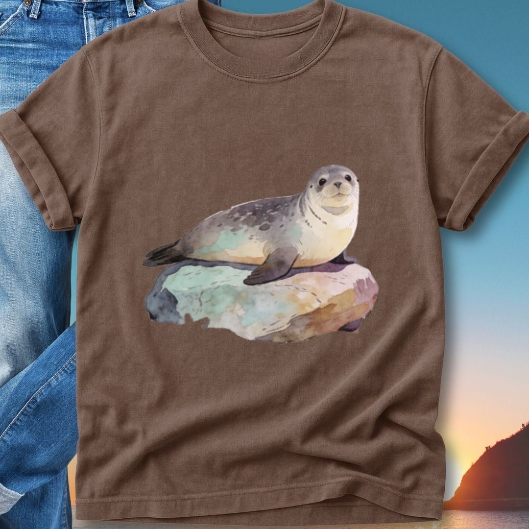 Watercolor seal resting on a rock with a sunset background.