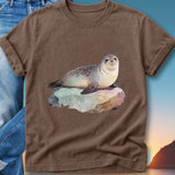 Watercolor seal resting on a rock with a sunset background.