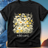 Black t-shirt with a bouquet of white and yellow wildflowers and text "wild card."