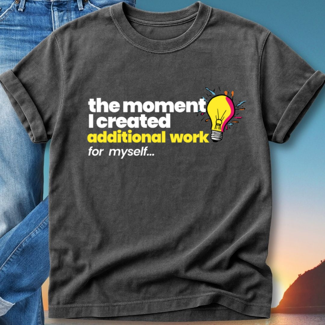 Dark t-shirt with text "the moment I created additional work for myself..." and a lightbulb graphic.