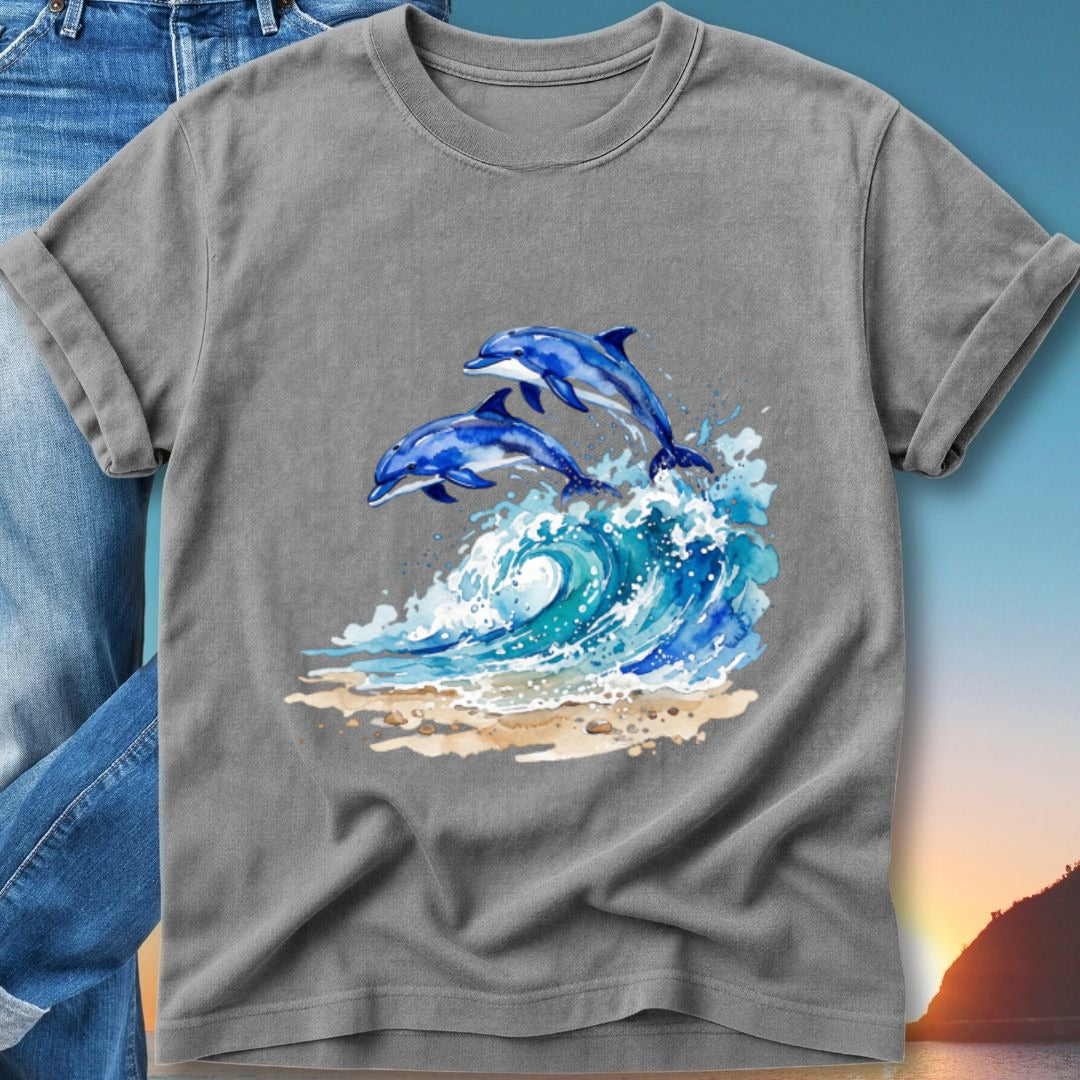 Two blue dolphins leap from a wave on a beach.