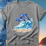 Two blue dolphins leap from a wave on a beach.
