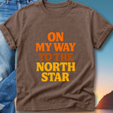 Brown t-shirt with "ON MY WAY TO THE NORTH STAR" text.