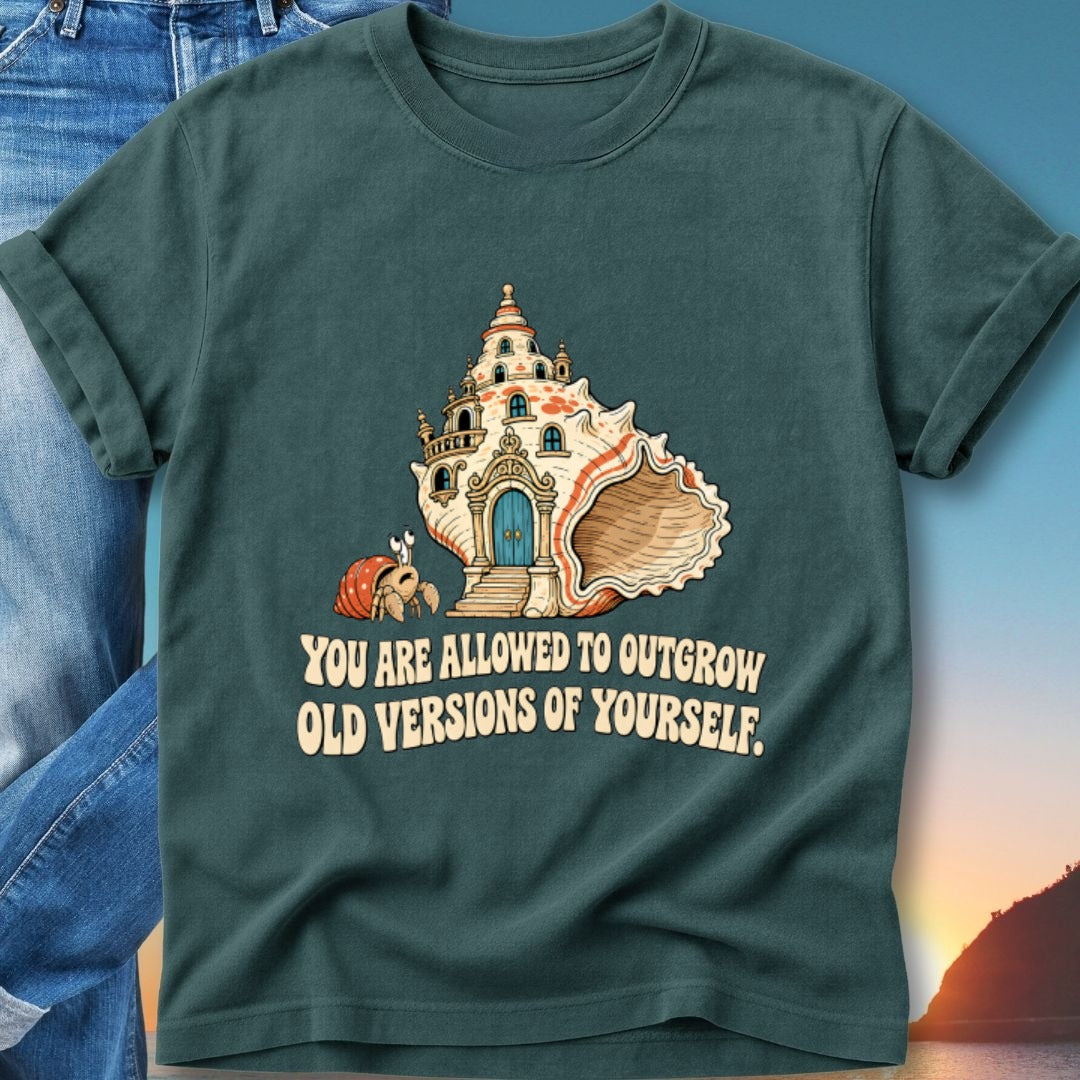 T-shirt with a seashell house and hermit crab, text reads "You are allowed to outgrow old versions of yourself."