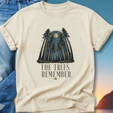 Cream t-shirt with forest silhouette, moon, and "The Trees Remember" text.