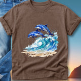 Two dolphins jump from a crashing wave onto a sandy beach at sunset.