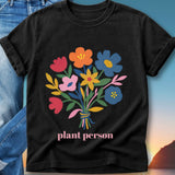 Black t-shirt with a colorful floral bouquet and the text "plant person".