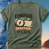 Olive green t-shirt with compass, map, and "Trust the Compass Question the Plan" text.