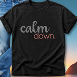 Black t-shirt with "calm down." text in gray and pink.