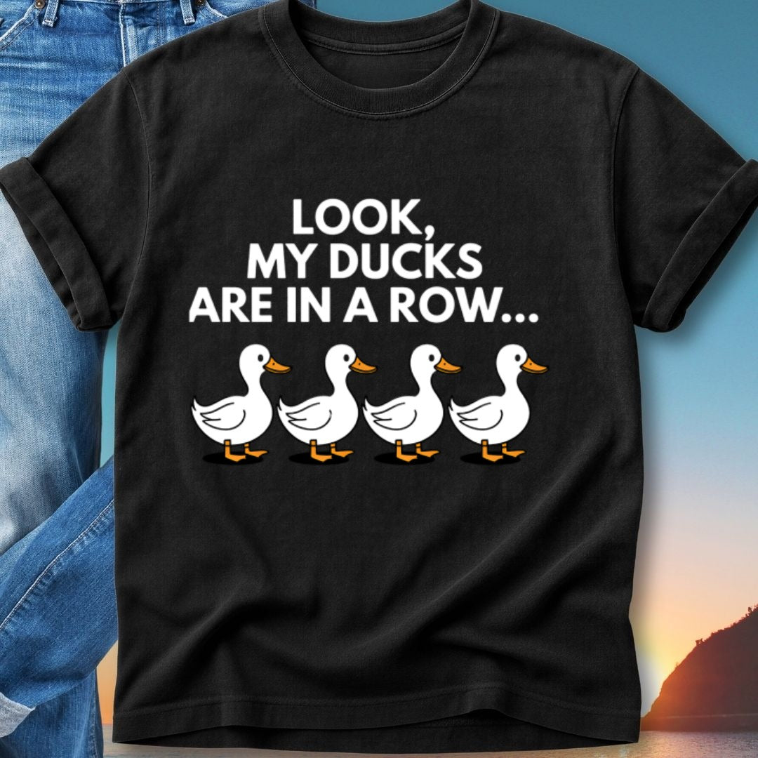 Black t-shirt with "Look, MY DUCKS ARE IN A ROW..." and four cartoon ducks.